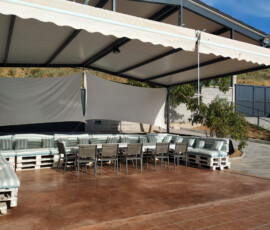 Amplia terraza cubierta con zona chill-out en el alojamiento rural
