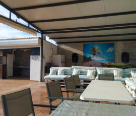 Zona común cubierta con cocina exterior y chill-out para los huéspedes